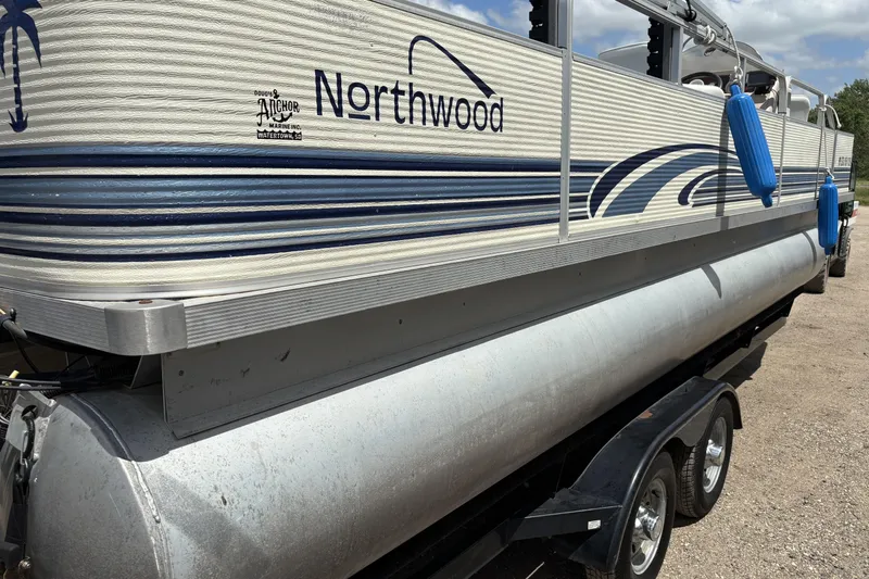 Slide: The Image of 1997 Northwood 24' Pontoon boat on trailer, featuring blue accents and protective bumpers. - 6