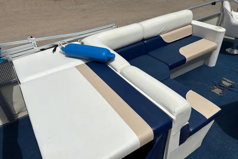 Slide: The Image of 1997 Northwood 24' Pontoon boat interior with blue and beige seating, blue fender on deck. - 12
