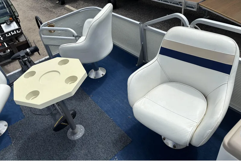 Slide: The Image of 1997 Northwood 24' Pontoon interior with white seating and a beige table. - 15
