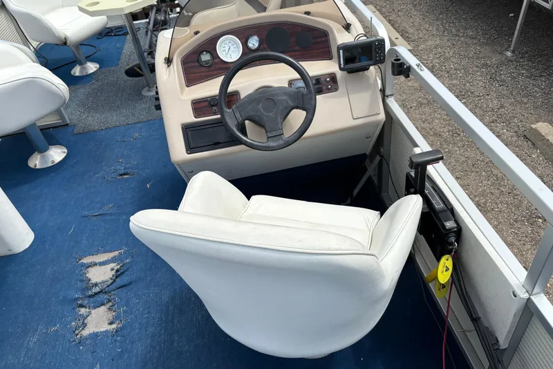 Slide: The Image of 1997 Northwood 24' Pontoon boat interior with steering wheel and white captain's chair. - 13