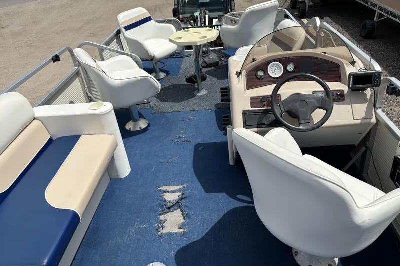 Slide: The Image of 1997 Northwood 24' Pontoon boat interior with worn blue carpet and white seating. - 16