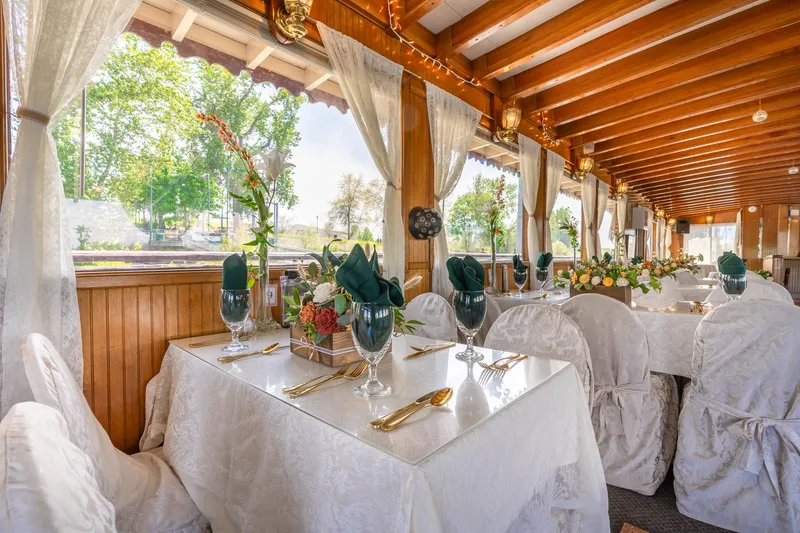 Slide: The Image of Elegant dining setup on 1990 Howdy Eidelman Sternwheeler, featuring white linens and floral arrangements. - 17