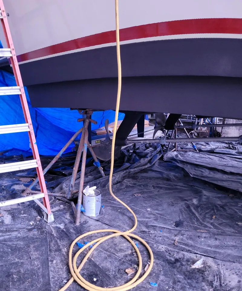 Slide: The Image of 1983 Ocean Yachts Super Sport undergoing maintenance with ladder and hose nearby. - 30