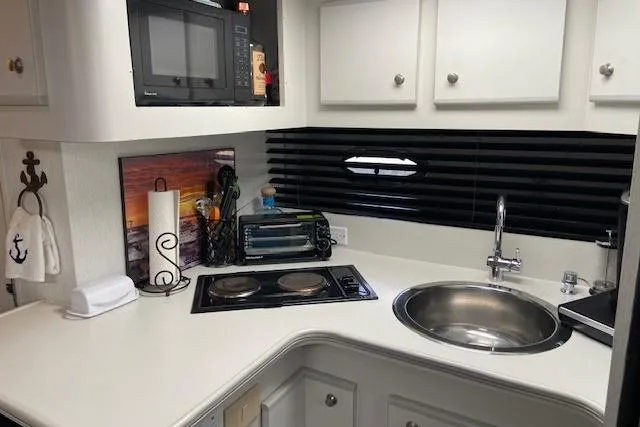 Slide: The Image of Compact kitchen area in a 1994 Cruisers Yachts 3675 Esprit with stove, sink, and microwave. - 12