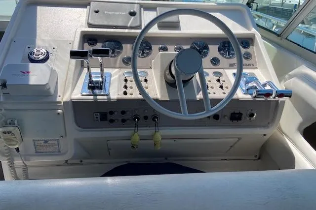 Slide: The Image of Control panel of a 1994 Cruisers Yachts 3675 Esprit boat, featuring steering wheel and gauges. - 3