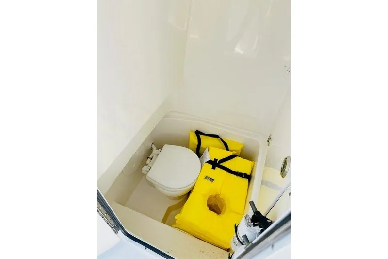 Slide: The Image of Interior of 2023 Contender 24 Sport boat with toilet and yellow life jackets. - 19