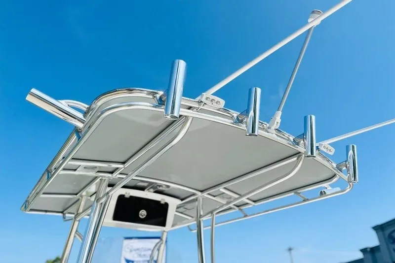 Slide: The Image of 2023 Contender 24 Sport boat's T-top with rod holders against clear blue sky. - 11