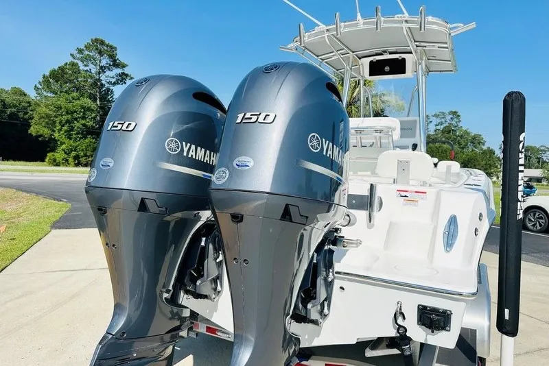 Slide: The Image of 2023 Contender 24 Sport boat with dual Yamaha 150 engines, parked outdoors. - 6