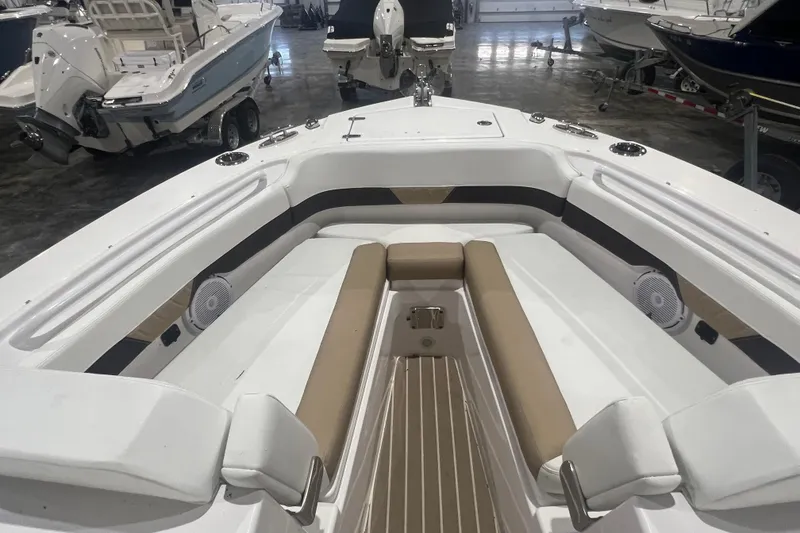 Slide: The Image of 2023 Edgewater 230CX Crossover boat interior with cushioned seating and speakers. - 4