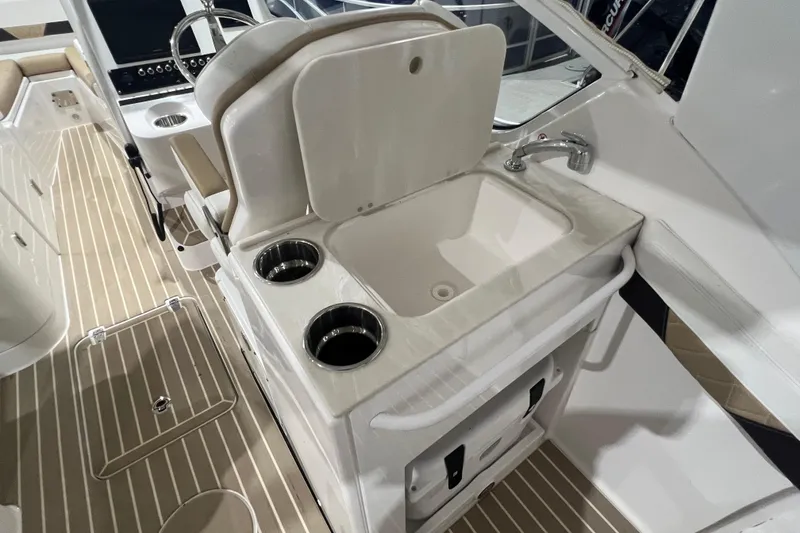 Slide: The Image of 2023 Edgewater 230CX Crossover boat interior with sink and cup holders. - 17