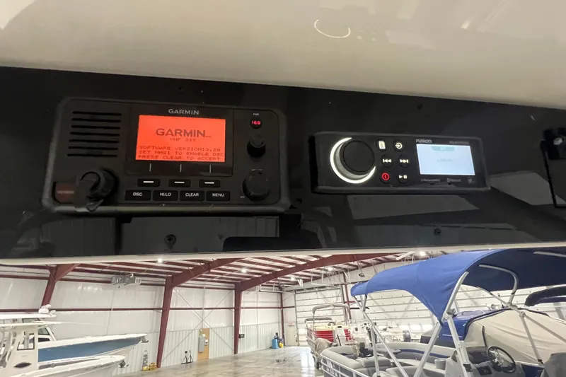 Slide: The Image of 2023 Edgewater 230CX Crossover boat with Garmin and Fusion marine electronics in a showroom. - 16