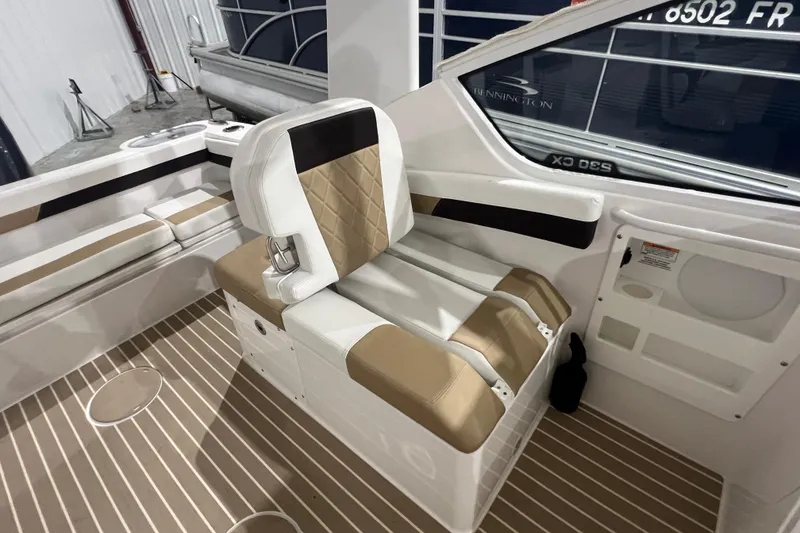 Slide: The Image of 2023 Edgewater 230CX Crossover boat interior with tan and white seating. - 6
