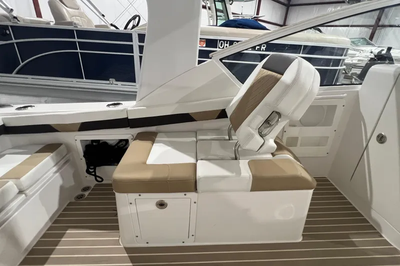 Slide: The Image of 2023 Edgewater 230CX Crossover boat interior with beige and white seating. - 15
