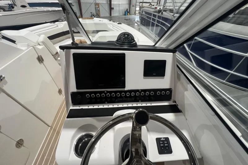 Slide: The Image of Interior view of 2023 Edgewater 230CX Crossover boat cockpit with steering wheel and control panel. - 11