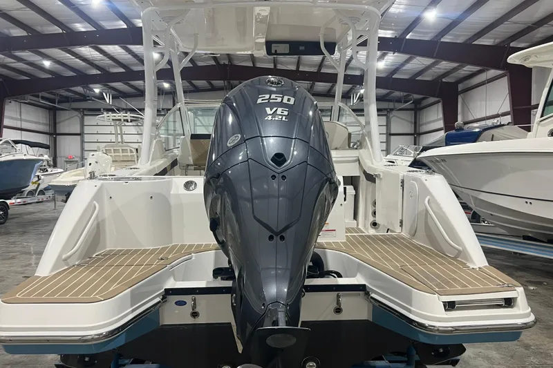 Slide: The Image of 2023 Edgewater 230CX Crossover boat with powerful V6 engine in showroom. - 2