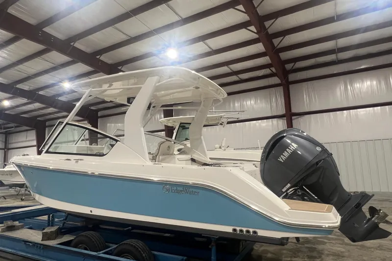 Slide: The Image of 2023 Edgewater 230CX Crossover boat with Yamaha engine in a warehouse setting. - 3