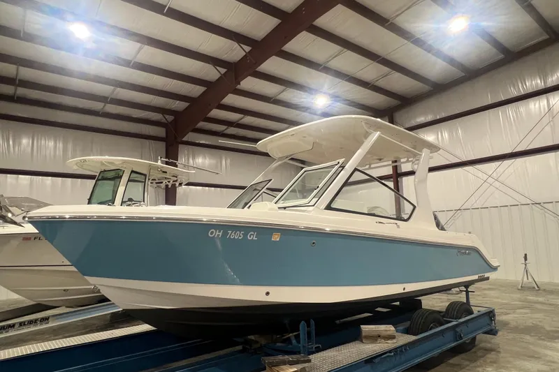 The Image of 2023 Edgewater 230CX Crossover boat in indoor storage facility. - 0