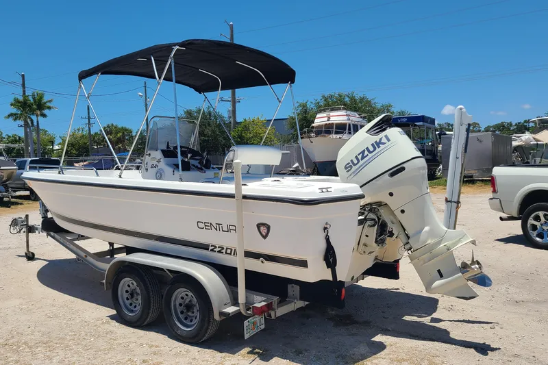 Slide: The Image of Century 2201 Bay Boat 2001 with Suzuki outboard motor on trailer, parked outdoors. - 3