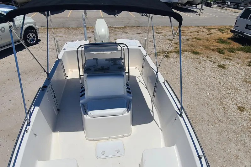 Slide: The Image of 2001 Century 2201 Bay Boat with canopy, parked on gravel lot. - 6