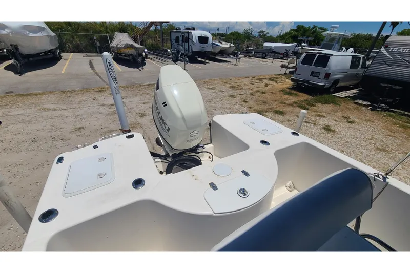 Slide: The Image of 2001 Century 2201 Bay Boat with Suzuki outboard motor in a storage yard. - 11