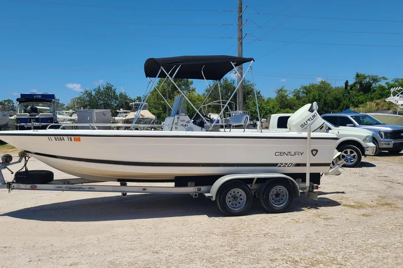 The Image of 2001 Century 2201 Bay Boat on trailer, parked outdoors under clear blue sky. - 0