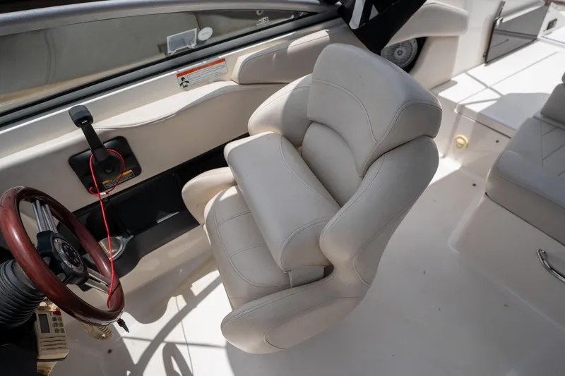 Slide: The Image of Interior of a 2008 Regal 2000 Bowrider boat, featuring a plush captain's chair and steering wheel. - 23