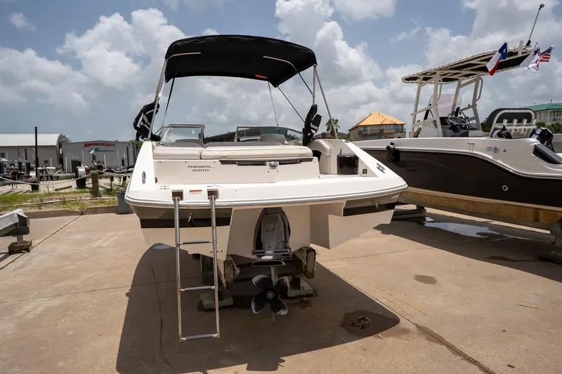 Slide: The Image of 2008 Regal 2000 Bowrider boat with ladder, displayed outdoors on a sunny day. - 11