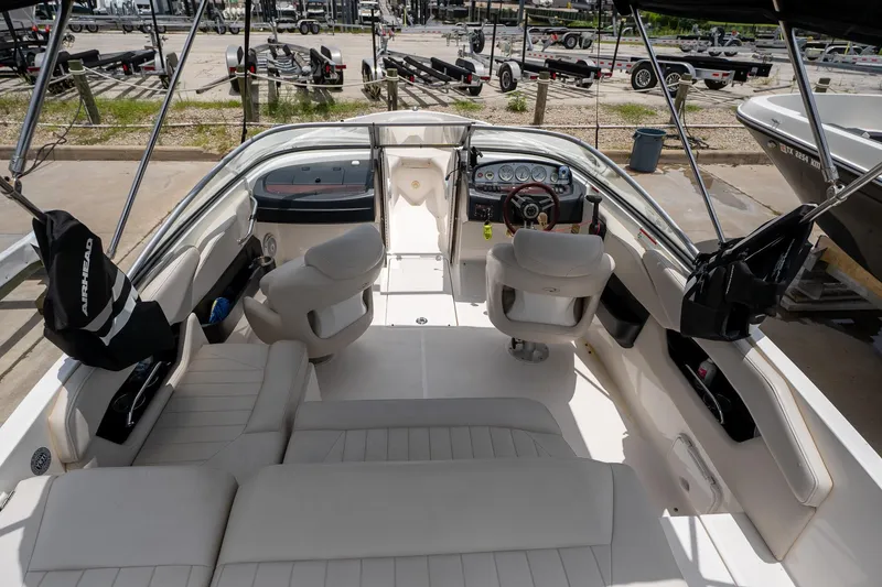 Slide: The Image of 2008 Regal 2000 Bowrider boat interior with seating and dashboard, parked at marina. - 15