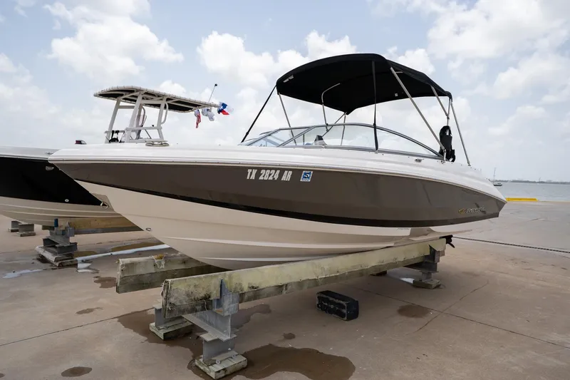 Slide: The Image of 2008 Regal 2000 Bowrider boat on dock, featuring sleek design and canopy under cloudy sky. - 9