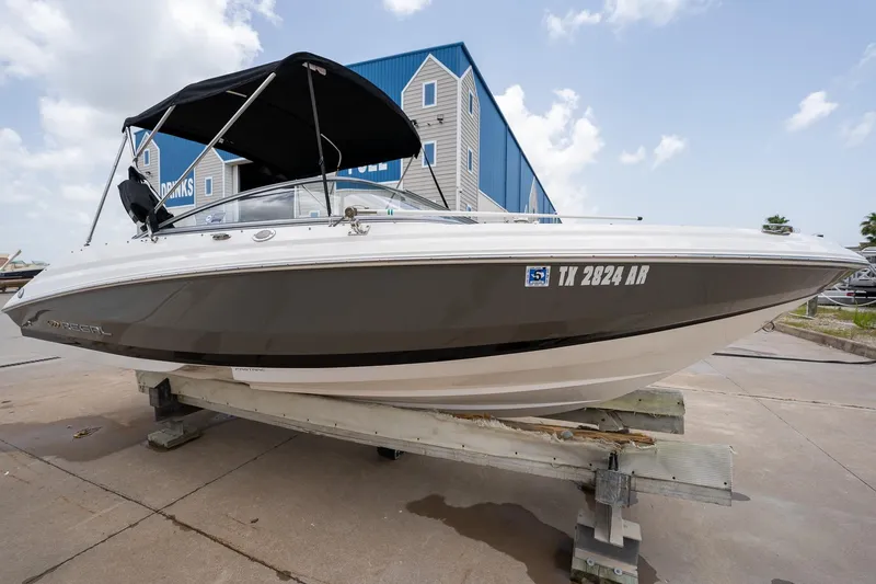 Slide: The Image of 2008 Regal 2000 Bowrider boat on display, featuring sleek design and black canopy. - 6