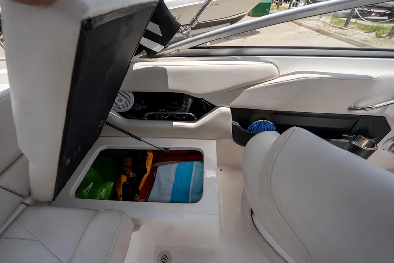 Slide: The Image of Interior storage compartment of a 2008 Regal 2000 Bowrider boat with various items inside. - 34