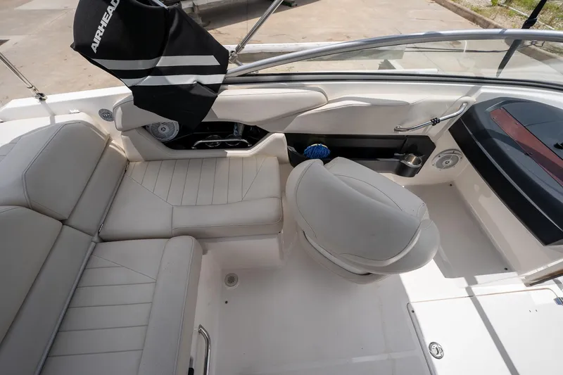 Slide: The Image of Interior of 2008 Regal 2000 Bowrider boat with white seating and steering area. - 18