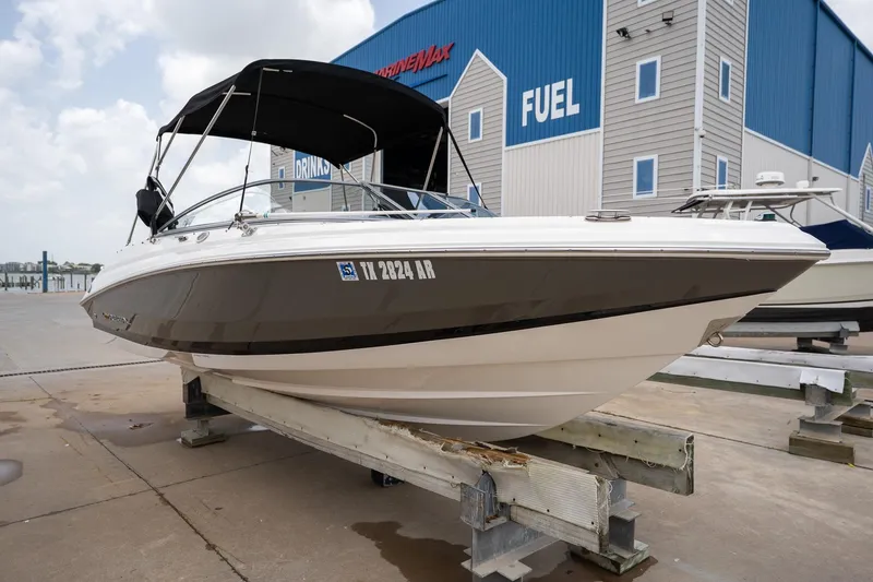 Slide: The Image of 2008 Regal 2000 Bowrider boat on dock, near blue fuel station building. - 8