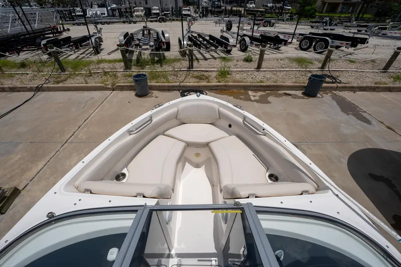 Slide: The Image of 2008 Regal 2000 Bowrider boat interior with seating, parked on concrete near trailers. - 17