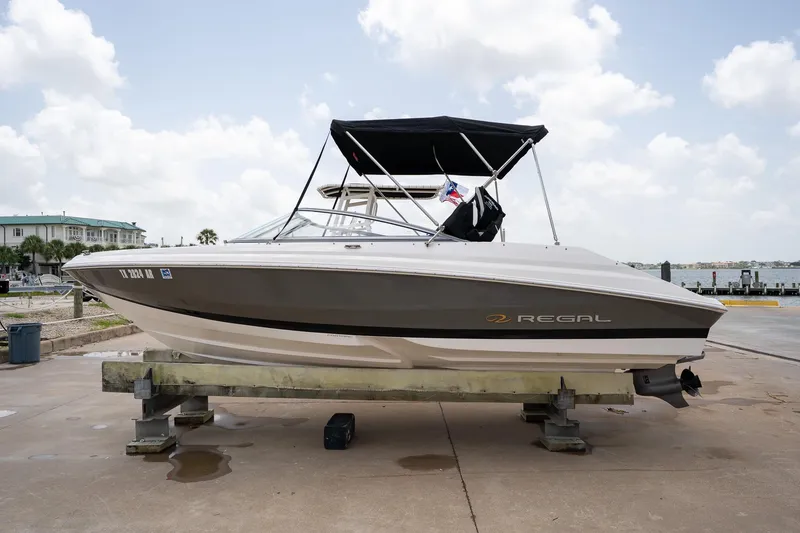 Slide: The Image of 2008 Regal 2000 Bowrider boat on a dock, featuring sleek design and canopy. - 10