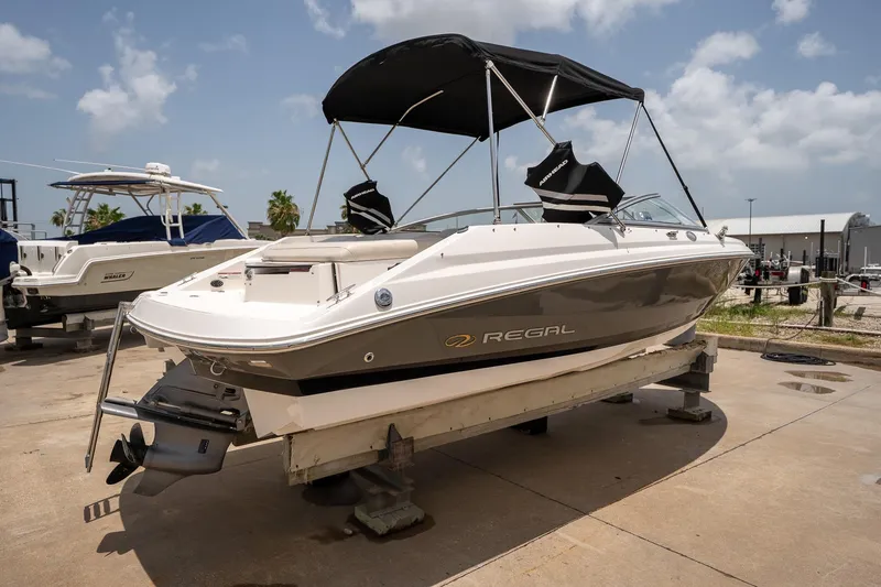 The Image of 2008 Regal 2000 Bowrider boat on a stand, featuring a sleek design and canopy. - 2