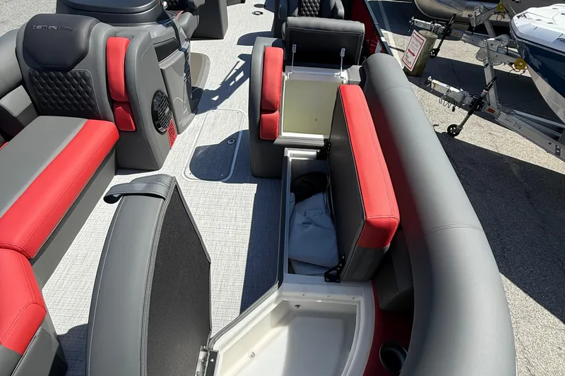 Slide: The Image of 2026 Berkshire 23RFX STS boat interior with red and gray seating, open storage compartments. - 14