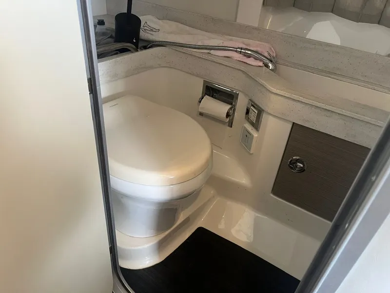Slide: The Image of The image shows a clean, modern boat toilet with white fixtures and a towel. - 9