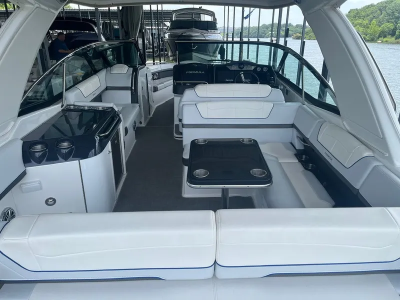 Slide: The Image of The image shows the interior of a 2019 Formula 350 Crossover Bowrider with white seating and a table. - 18