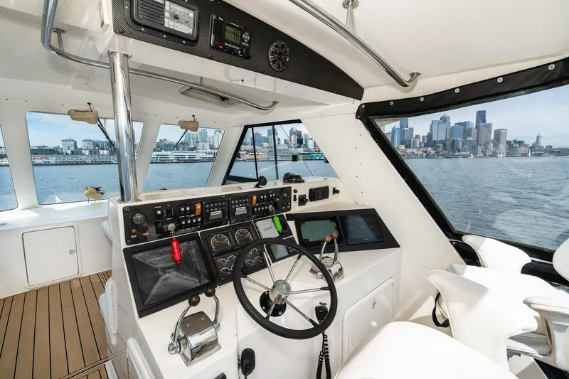 Slide: The Image of Cockpit view of 1999 Riviera 48 Convertible yacht with city skyline in background. - 11