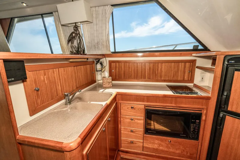 Slide: The Image of Luxurious kitchen interior of 1999 Riviera 48 Convertible yacht with wooden cabinetry. - 37