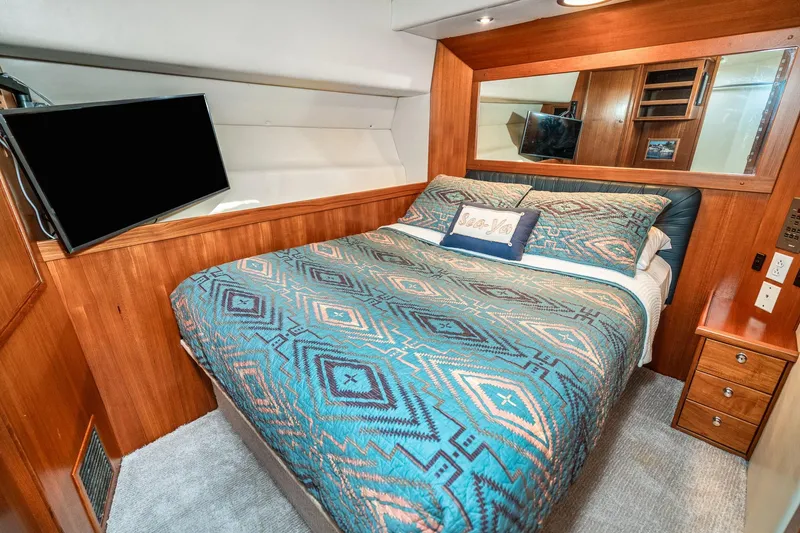 Slide: The Image of Luxurious bedroom interior of 1999 Riviera 48 Convertible yacht with patterned bedding and TV. - 46