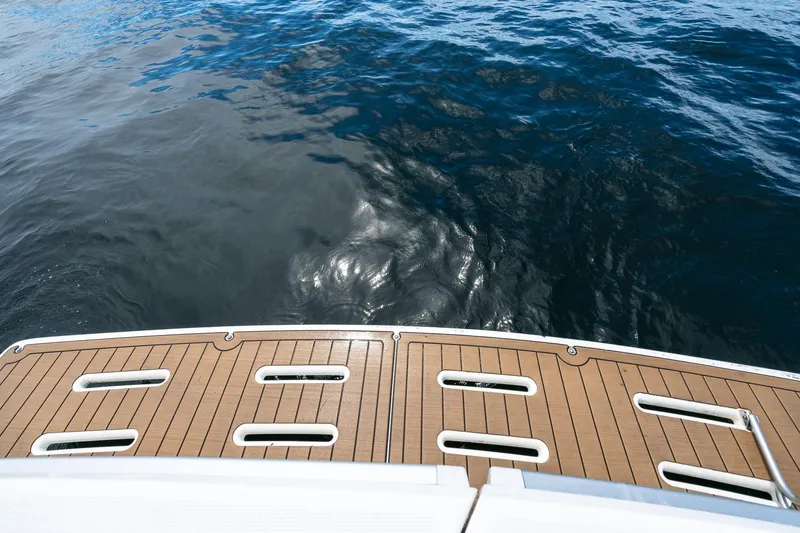 Slide: The Image of Teak swim platform of 1999 Riviera 48 Convertible yacht on calm water. - 23