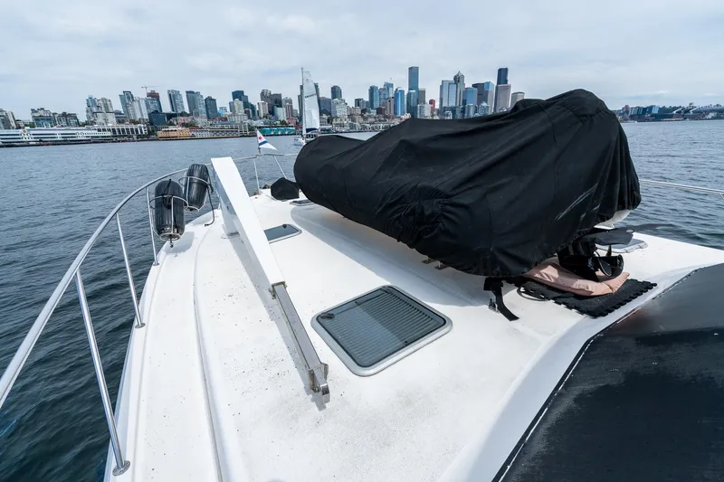 Slide: The Image of 1999 Riviera 48 Convertible yacht with city skyline in the background. - 61