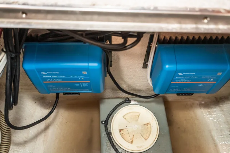 Slide: The Image of Electrical system in a 1999 Riviera 48 Convertible boat, featuring blue smart chargers. - 55