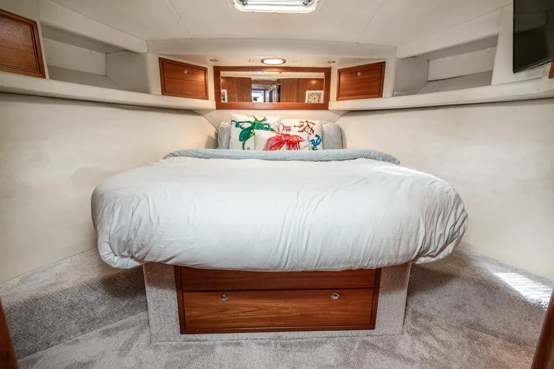 Slide: The Image of Cozy bedroom interior of 1999 Riviera 48 Convertible yacht with plush bedding and wooden accents. - 42