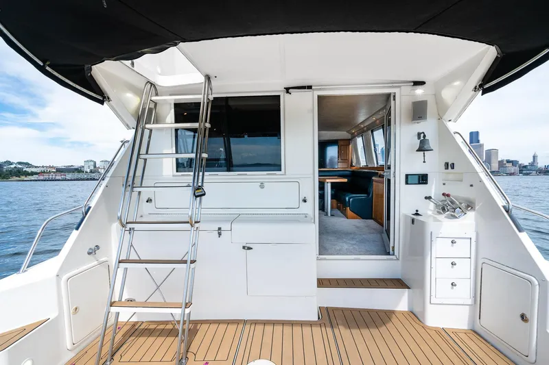 Slide: The Image of 1999 Riviera 48 Convertible yacht interior with ladder, seating, and city skyline view. - 28