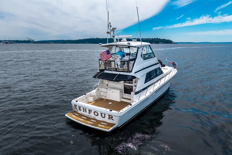 Slide: The Image of 1999 Riviera 48 Convertible yacht cruising on open water under a clear blue sky. - 6