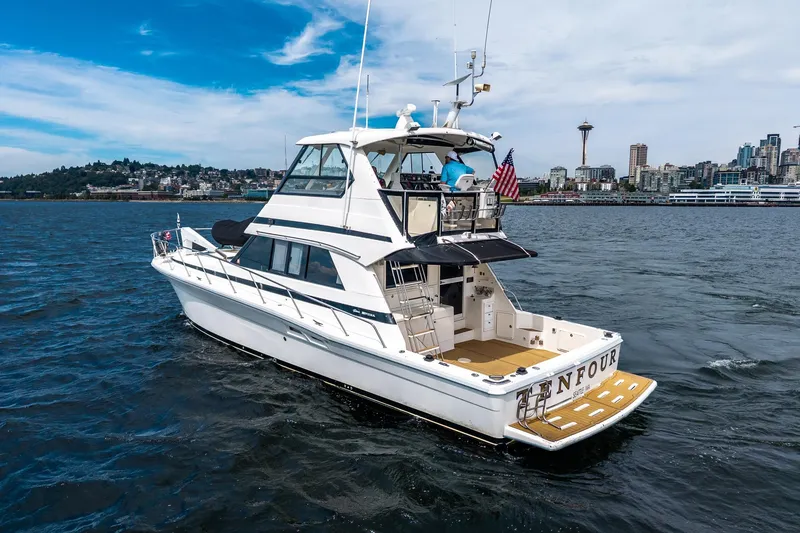 Slide: The Image of 1999 Riviera 48 Convertible yacht cruising near Seattle skyline on a sunny day. - 8