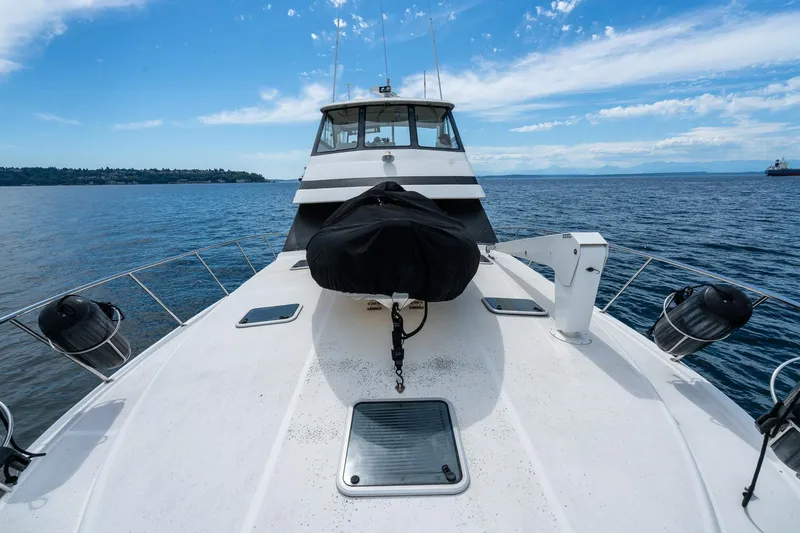 Slide: The Image of 1999 Riviera 48 Convertible yacht on open water under a clear blue sky. - 64